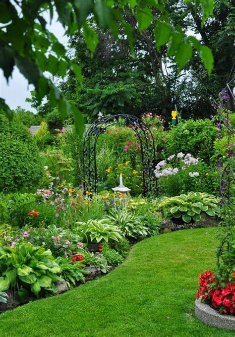 Country back formal full sun garden for summer in other with a retaining wall and natural stone paving. Country flower garden ideas 7 - gardenmagz.com