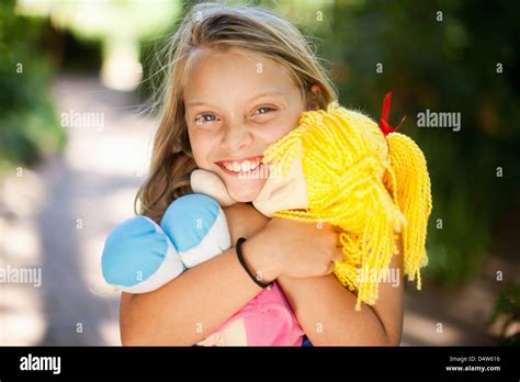 Smiling Girl Holding Doll Outdoors Stock Photo Alamy