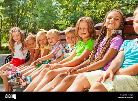 Beautiful Little Children Sit On Bench In Park Stock Photo Alamy