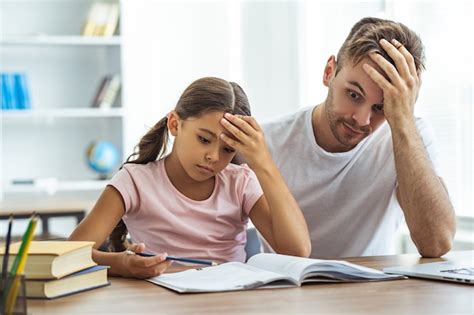 El Padre Cansado Y Una Hija Haciendo Los Deberes En La Mesa Foto Premium