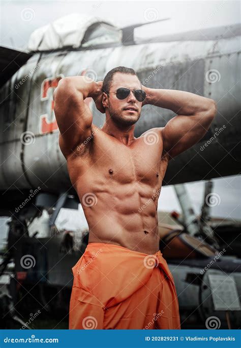 Naked Muscular Mechanic Posing Near Abandoned Airplane Stock Image