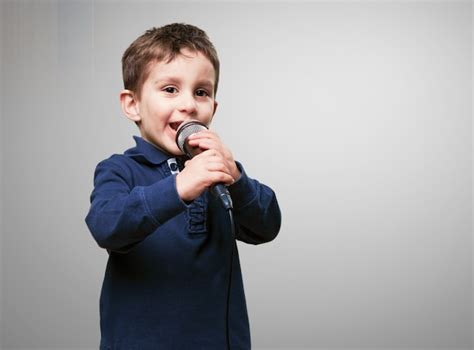 Child Singing Through A Microphone Photo Free Download