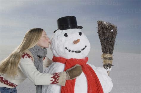 Germany Bavaria Munich Young Woman Kissing Snowman Portrait Stock Photo