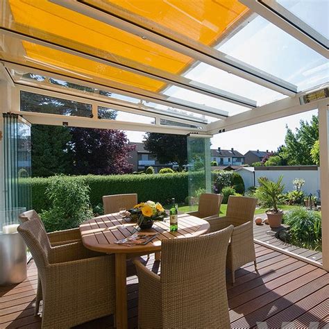 An elegant small terrace with blue upholstered chairs, a rug and a glass coffee table. Garden Glass Rooms & Verandas | Supply & Installation of High Quality Glass Rooms & Glass ...