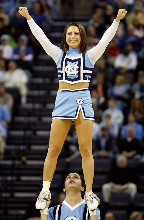 A Cheerleader Standing On The Back Of A Man