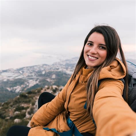 Free Photo Smiling Portrait Of A Young Female Hiker Taking Selfie