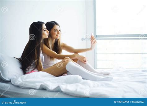 Duas Meninas Quentes Que Encontram Se Em Uma Cama Que Toma Uma Foto Dse Imagem De Stock Imagem