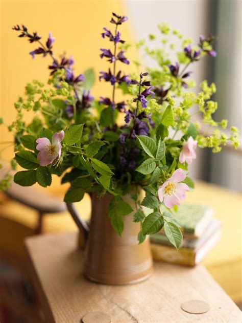 A Vase Filled With Purple Flowers Sitting On Top Of A Wooden Table Next