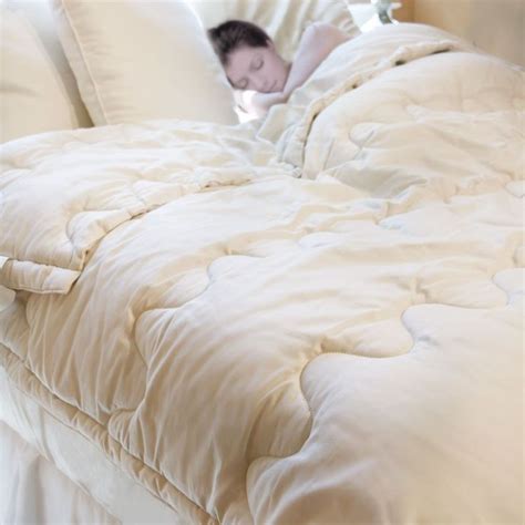 A Person Sleeping In A Bed With White Sheets And Pillows On Top Of The