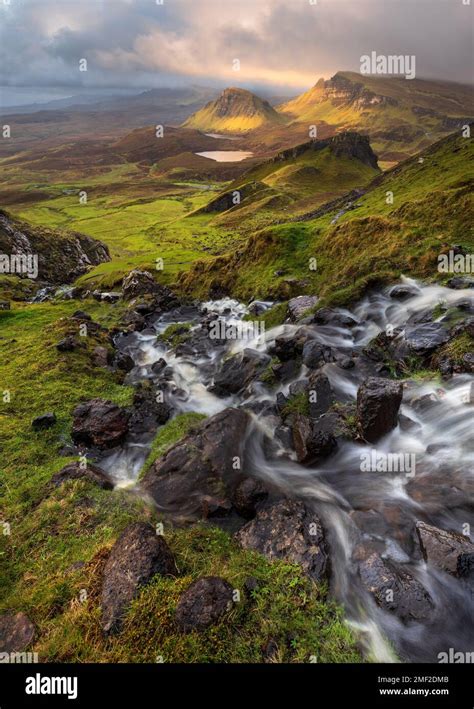 Flowing Waterfall With Dramatic View Of Scottish Landscape At The