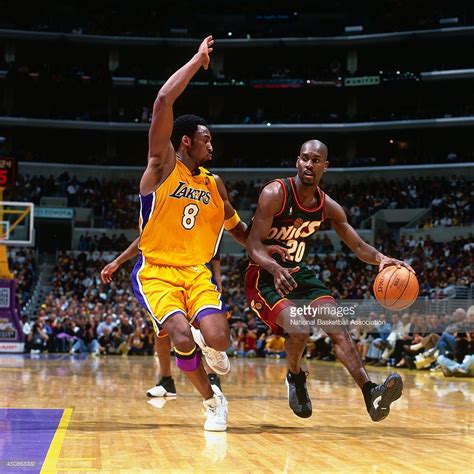 Gary Payton Of The Seattle Supersonics Drives To The Basket Against Kobe Bryant