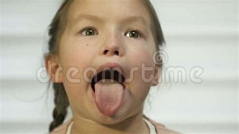 Girl Of 7 8 Years Old Diligently Shows Her Tongue Perhaps At A Doctor