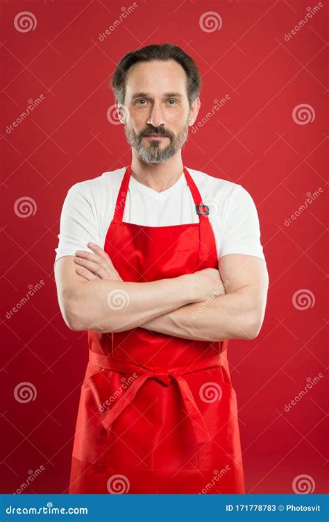 Confident In His Culinary Craft Cook With Beard And Mustache Wearing Apron Red Background Man