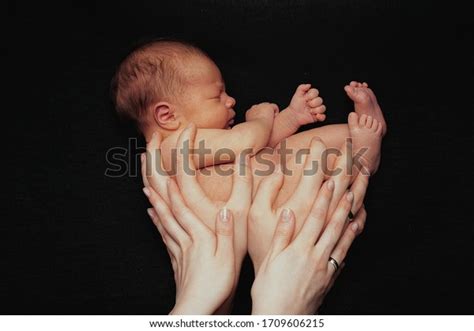 Newborn Baby Lying On Parents Hands Naked Newborn Babyon The Black Background Love And Warmth