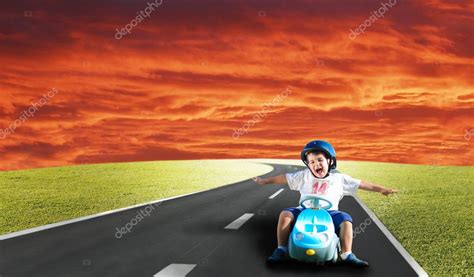 Niño Feliz En El Prado Verde Conduciendo Un Coche Fotografía De Stock
