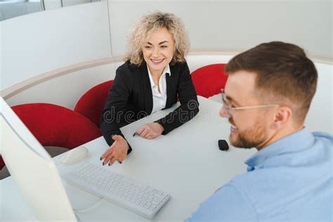 Woman Car Sales Manager Showing Options To A Male Client On Computer