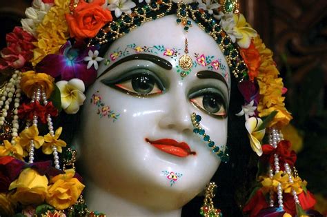 A Close Up Of A Statue With Flowers On Its Head And Eyes Painted White
