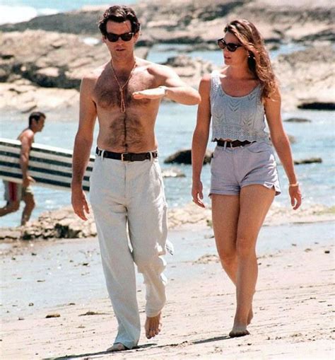 The Man And Woman Are Walking On The Beach