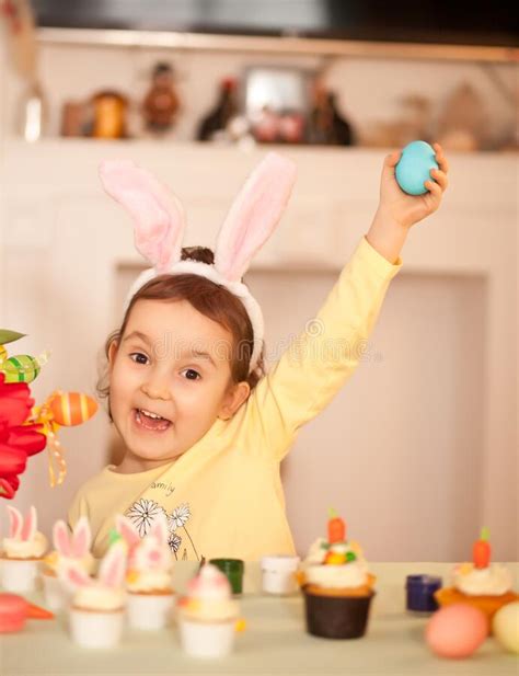 Funny Girl Child Wearing Bunny Ears And Painting Easter Egg In Spring