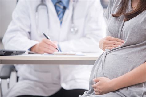 Portrait Of Pregnant Woman With Doctor In Clinic The Pulse