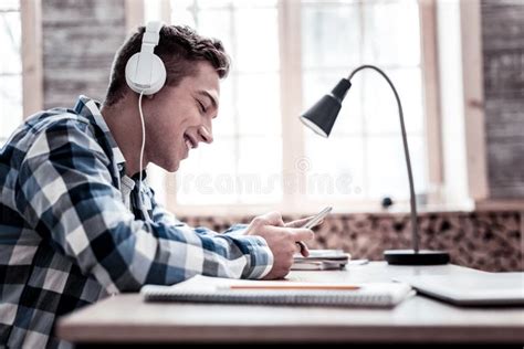 Handsome Student Listening To Music While Doing Homework Stock Image