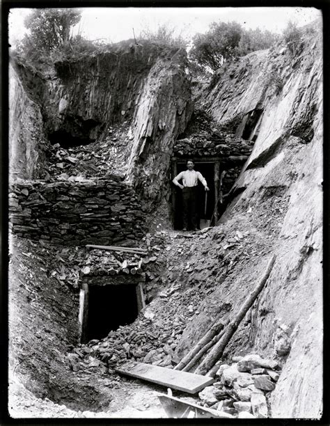 Entrances To Two Mine Shafts Man With Shovel Standing At