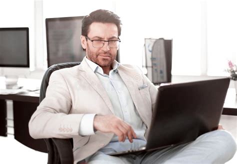 Businessman Using A Laptop Sitting At His Desk Stock Photo Image Of