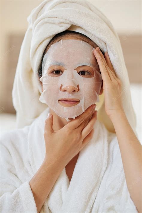 Premium Photo Woman Applying Rejuvenating Mask