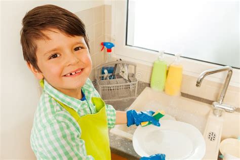 Happy Boy Washing Dishes Standing Next To The Sink Stock Image Image