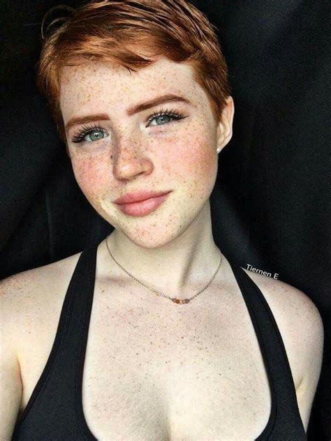 A Woman With Freckled Hair Wearing A Black Top And Posing For The Camera