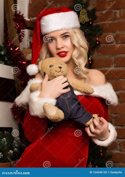Christmas Girl Holding Teddy Bear Blonde Woman Dressed As Santa In Front Of Camera Stock Photo