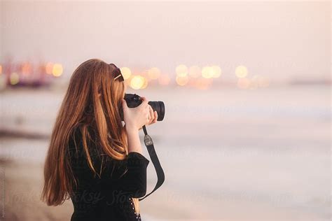 Teenage Girl Taking Photos At The Beach Del Colaborador De Stocksy