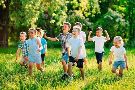Un Grupo De Niños Felices De Niños Y Niñas Corren En El Parque Sobre El
