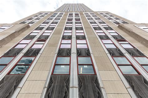 An Upward View Of The Side Of A Tall Building With Lots Of Windows On