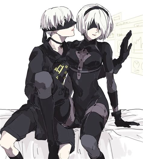 Two People In Black Catsuits Sitting On A Bed