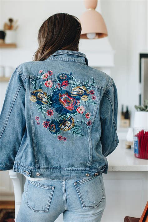 blue denim jacket with floral embroidered details on back and front pockets available in