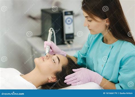 Professional Female Cosmetologist Doing Hydrafacial Procedure For