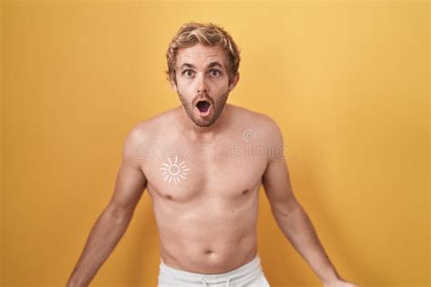 Caucasian Man Standing Shirtless Wearing Sun Screen Afraid And Shocked With Surprise And Amazed