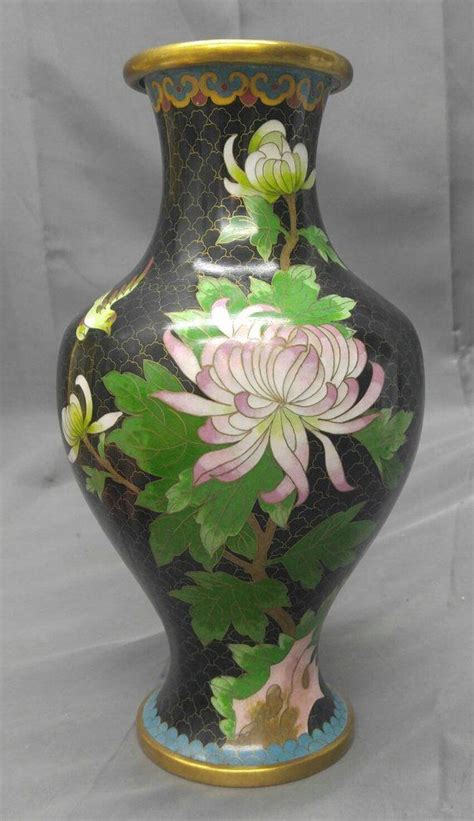 Elegant and romantic background with swallows. Vintage black Chinese cloisonne vase floral flower with ...