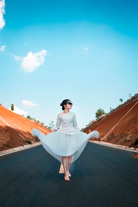 Woman In White Dress Walking Along Road · Free Stock Photo