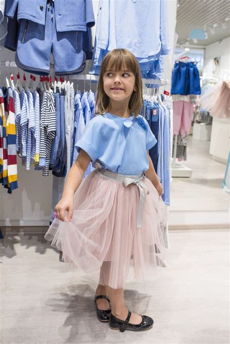 A Little Girl In A Clothing Store Chooses A Dress Shopping Stock Image
