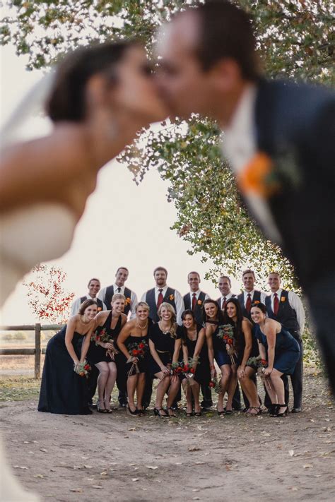 a bride and groom kissing in front of their wedding party