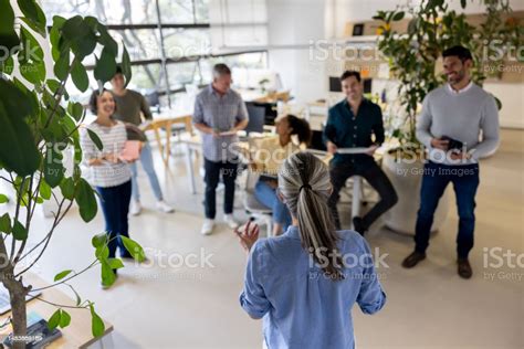 Boss Giving A Pep Talk To Her Team In A Business Meeting At The Office