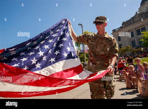 A Member Of The United States Army Unfurls A Folded Flag During The