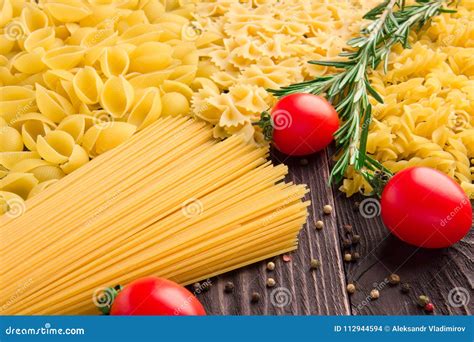 Variety Of Kinds And Forms Of Dry Macaroni With Tomatoes And Rosemary