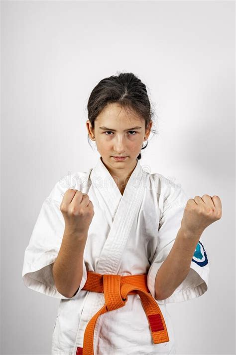 karate girl on a white background sporty caucasian brunette in a white kimono with an orange