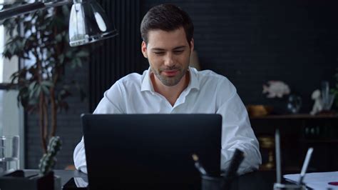Smiling Businessman Working On Laptop Computer At Home Office Male