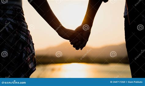Two Partner Holding Hand In Front Of The Mountain During Sunset