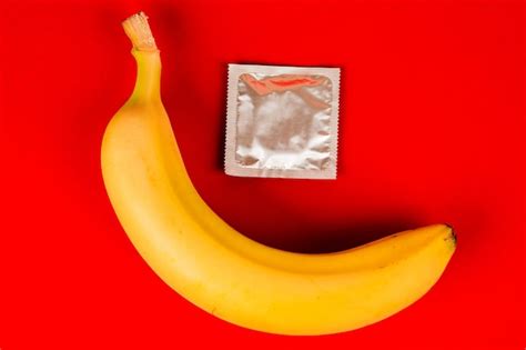 Premium Photo A Condom And A Banana Safe Sex Sex Toy On Red Background