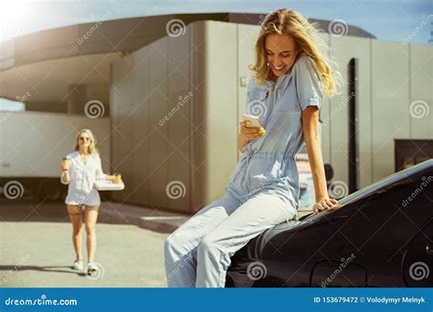 Young Lesbian`s Couple Preparing For Vacation Trip On The Car In Sunny